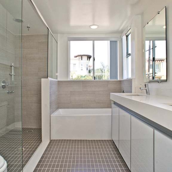 master bathroom with double sinks, full-size bathtub, and walk-in shower