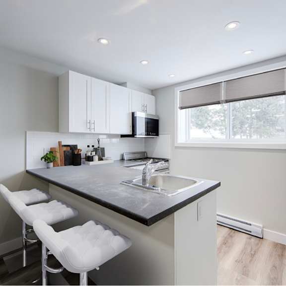 modern kitchen with stainless steel appliances and vinyl plank flooring.