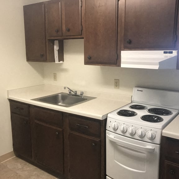 kitchen with dark wood cupboards with white appliances