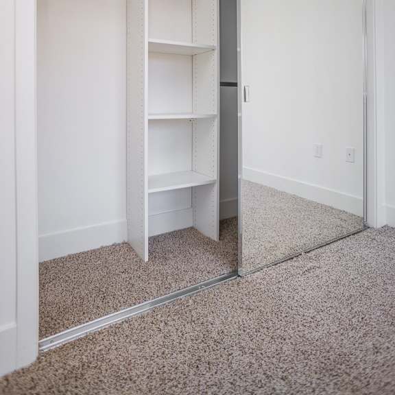 bedroom with a mirrored closet with built-in shelves