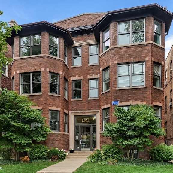 a brick building with a green lawn in front.