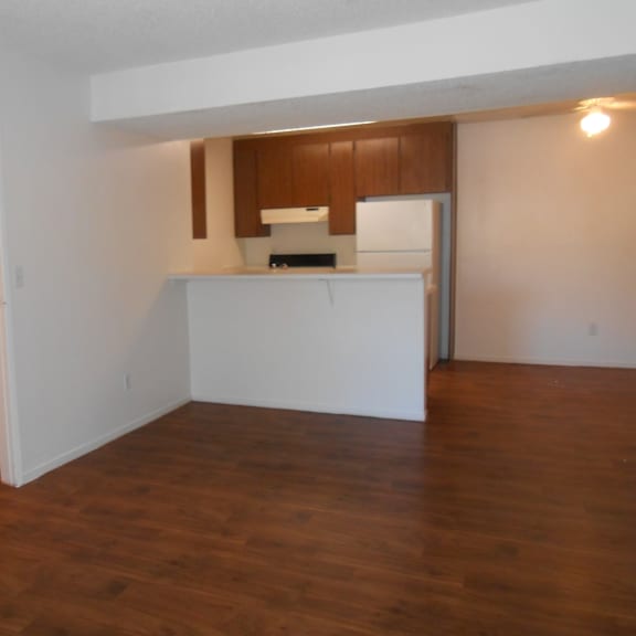 a kitchen area with a refrigerator, oven, and cabinets.