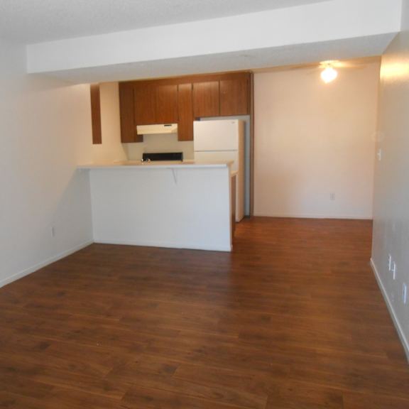 a kitchen with wooden floors and white walls.