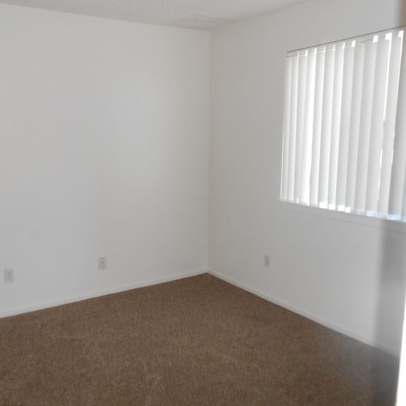 a room with white walls and a window with blinds.