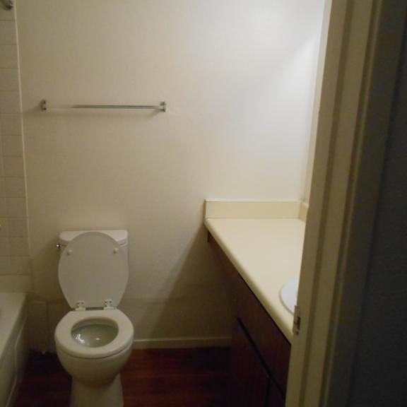 a white toilet in a small bathroom with a white bathtub and a white sink.