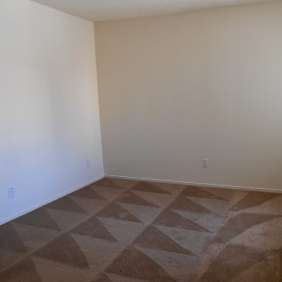 a room with a carpeted floor and a window.