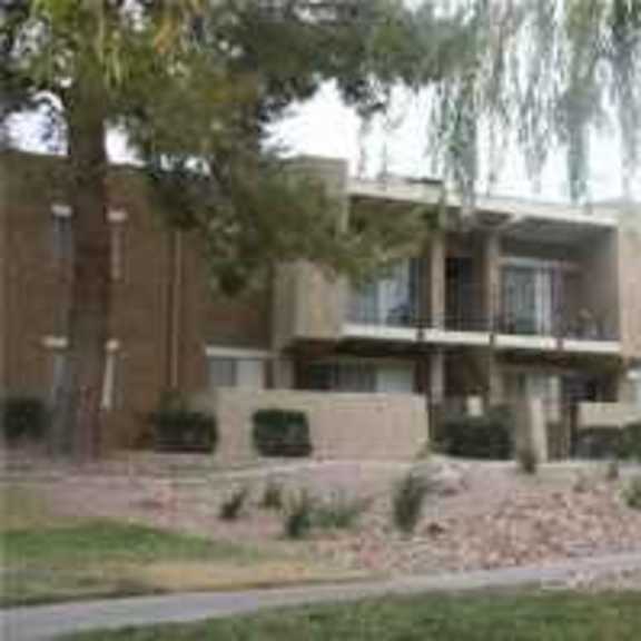 a brown building with a tree in front.