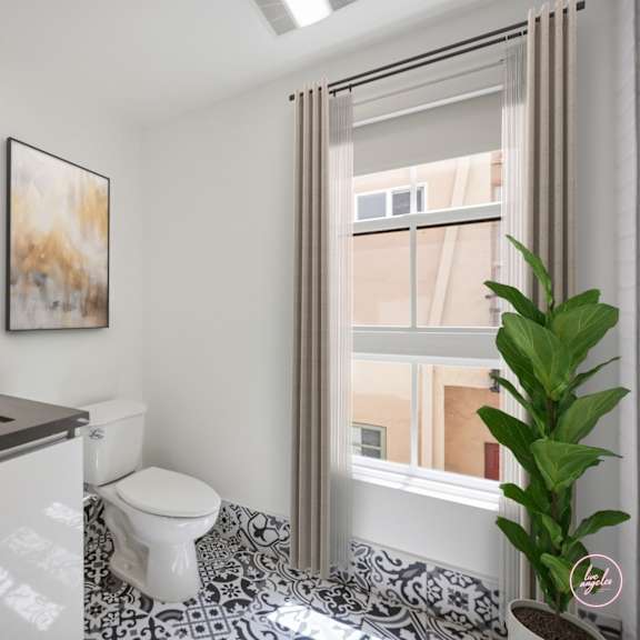 a bathroom with a toilet, sink, and a plant.