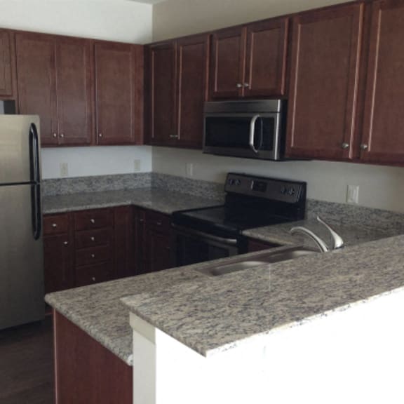 large kitchen with granite counter tops and stainless steel appliances