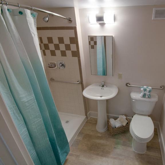 bathroom with shower stall and grab bars