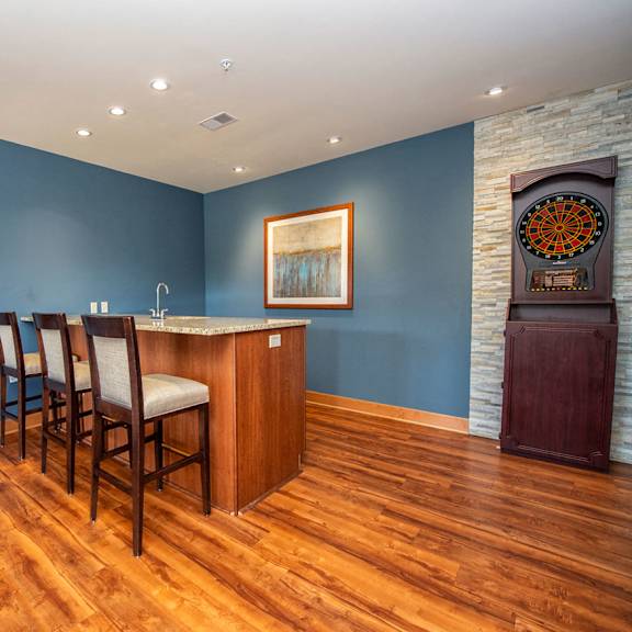 a living room with a bar and a blue wall and wood floors