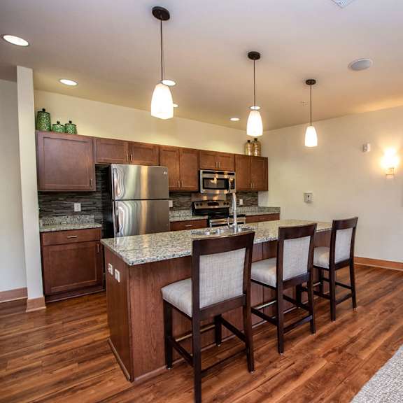 a kitchen and living room with a bar and chairs