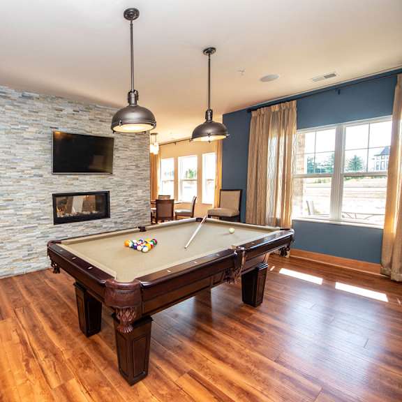 a pool table in a living room with a fireplace and a tv