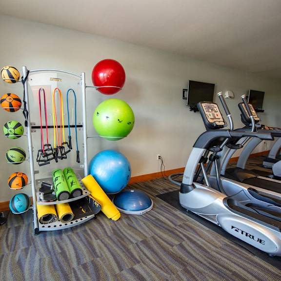 a gym with a treadmill and other exercise equipment in a room