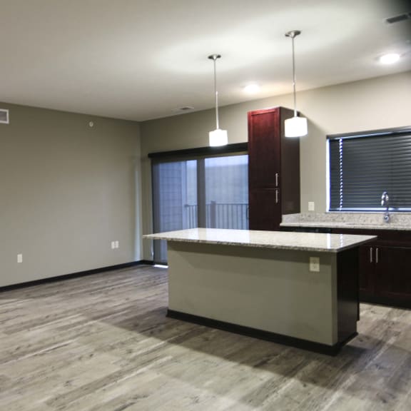 Thumbnail 2 of 19 Kitchen featuring light granite countertops, dark cabinetry and stainless-steel appliances at North Pointe Villas best new apartments Lincoln NE 68521