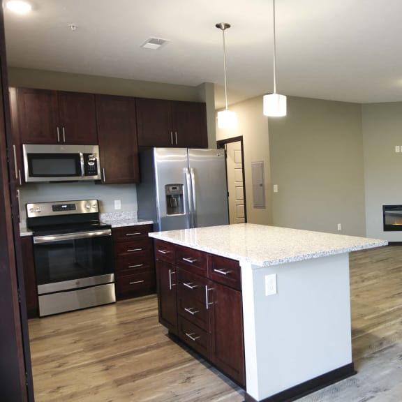 Thumbnail 4 of 19 Living and kitchen area with large island in a three bedroom Harrison floor plan