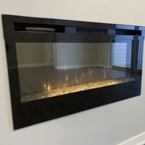 Thumbnail 7 of 21 A black fireplace with a fire burning inside.