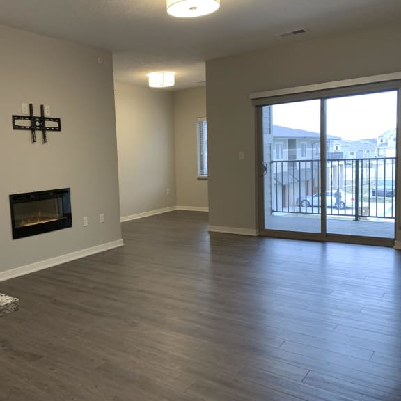 Thumbnail 8 of 21 A room with a fireplace and sliding glass doors.