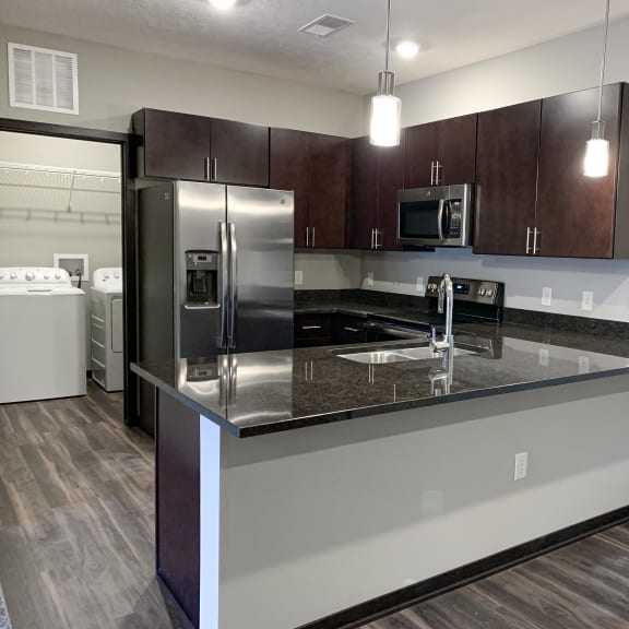 Thumbnail 19 of 21 A kitchen with dark wood cabinets and stainless steel appliances.