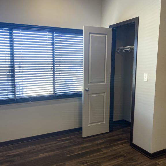 Thumbnail 18 of 23 A room with a door and a window with blinds.