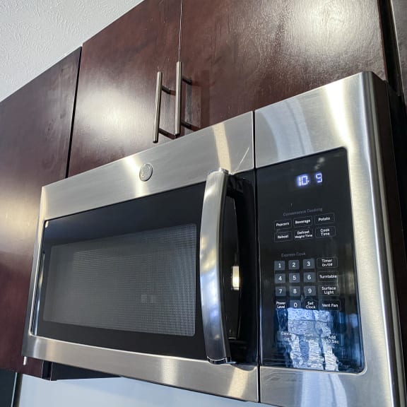 Thumbnail 21 of 23 A stainless steel microwave with digital display and control panel.
