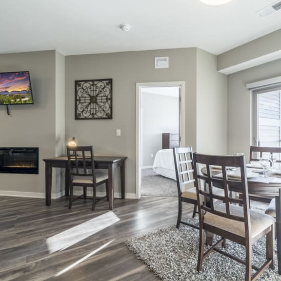 Thumbnail 6 of 23 A dining room with a fireplace and a television mounted on the wall.