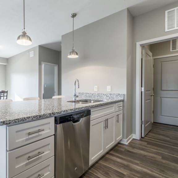 Thumbnail 8 of 23 A kitchen with a granite countertop and stainless steel appliances.