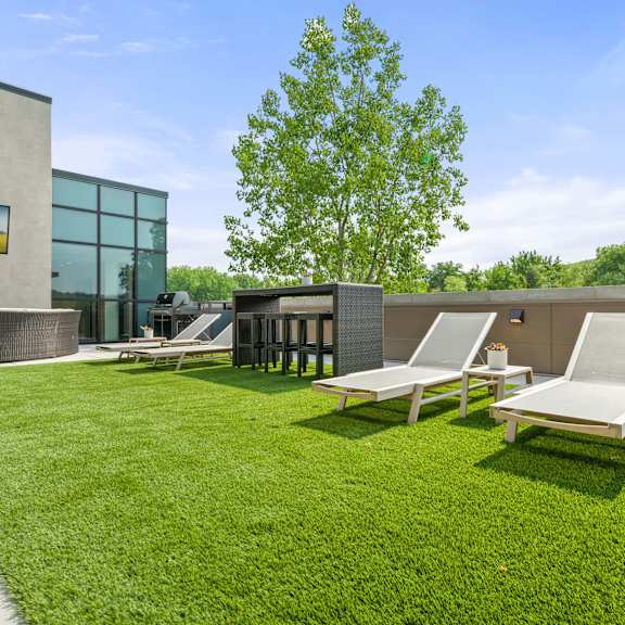 a rooftop patio with four lounge chairs and a small bar with barstools on artificial turf. at keva flats, exton, pa, 19341