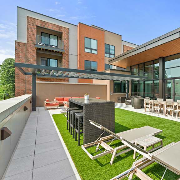 a rooftop lounge with fire pits, artificial turf, tables, chairs, and comfortable seating. at keva flats, pennsylvania, 19341