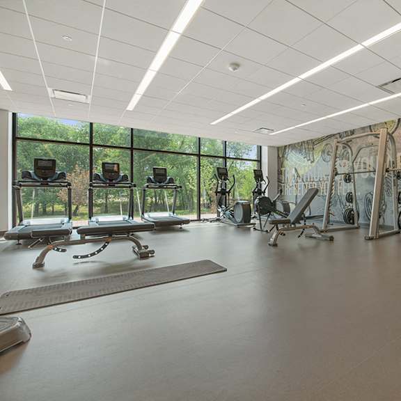 a state-of-the-art fitness with weight and cardio equipment and windows with beautiful view of green space  at keva flats, pennsylvania