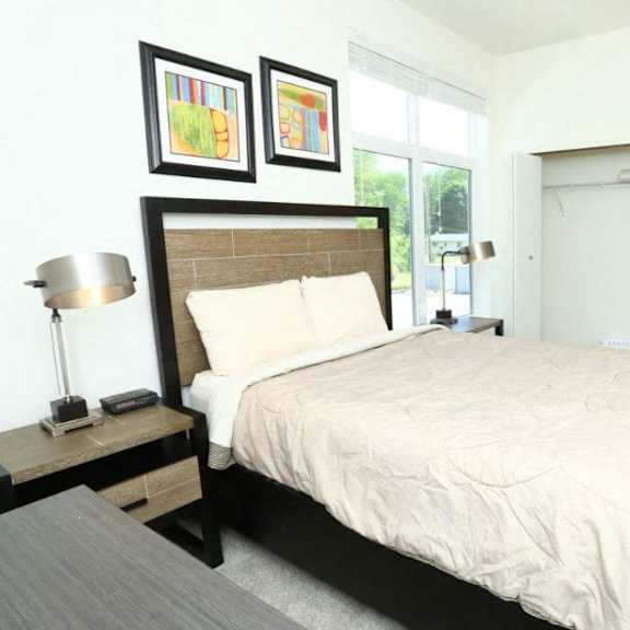 bedroom with a large bed and oversized windows  at brooks apartments, michigan