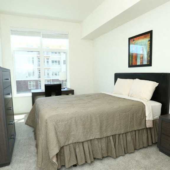 large bedroom with a bed and desk at brooks apartments, midland, michigan