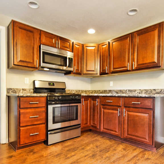 a kitchen with wooden cabinets and a granite countertop..