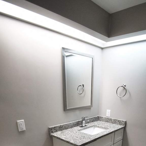 a bathroom with a toilet, sink, and mirror..