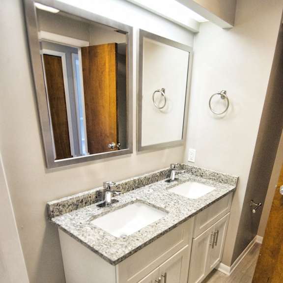 a bathroom with a sink, mirror, and tub..