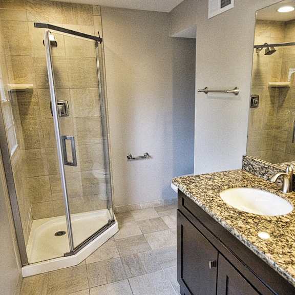 a bathroom with a walk-in shower and double sinks..