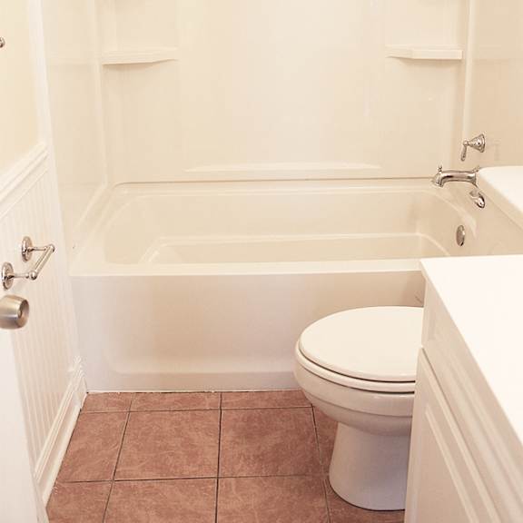 a white bathroom with a toilet and a bathtub.