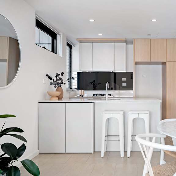 a kitchen and dining area with a white table and chairs