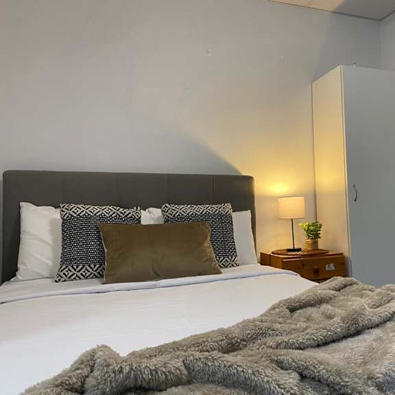 a bedroom with a bed with a blanket on top of it