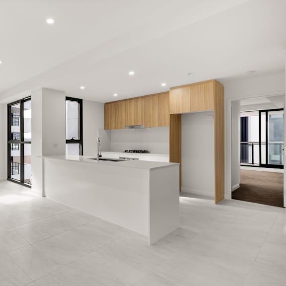 a modern kitchen with a white countertop and wooden accents.