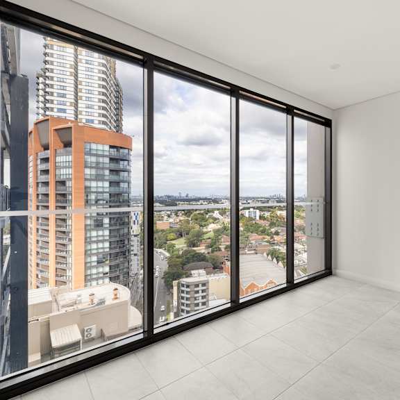 a large empty room with a view of the cityscape outside.