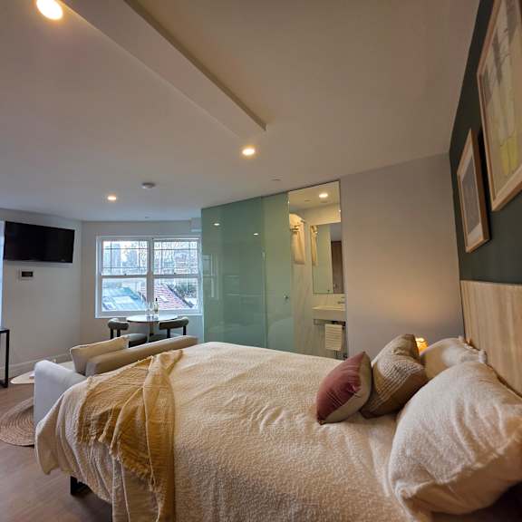 a bedroom with a large bed and a desk with a chair.