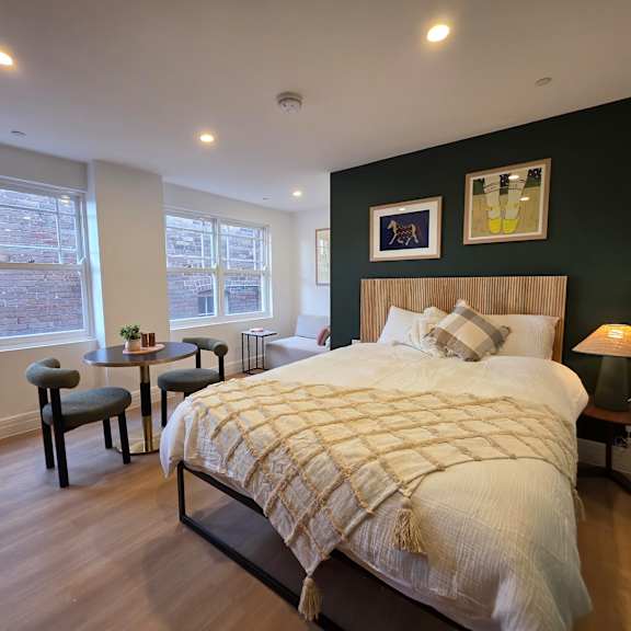 a bedroom with a large bed and a small table with a lamp.