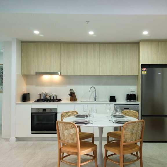 a modern kitchen with a dining table set for two.