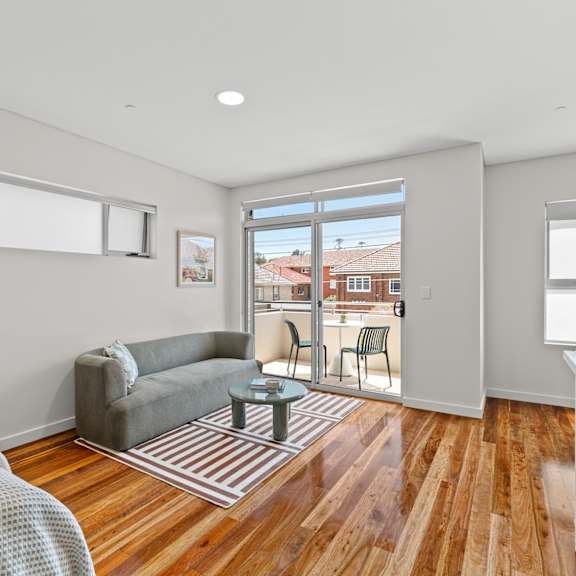 a bedroom with a bed, a couch, a chair, and a table.
