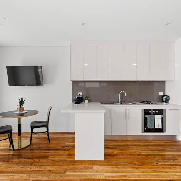 a modern kitchen with a table and chairs in the foreground.