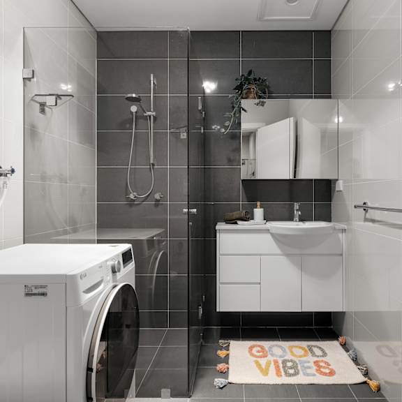 a bathroom with a washing machine in the corner.