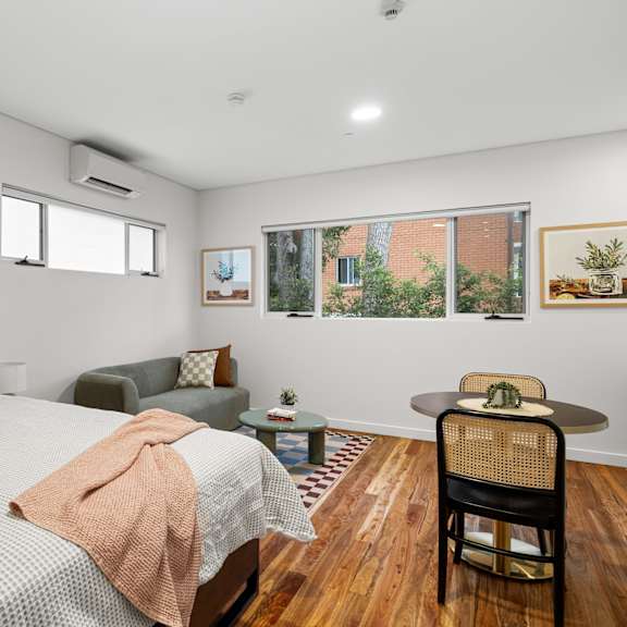 a bedroom with a bed, chair, and pictures on the wall.
