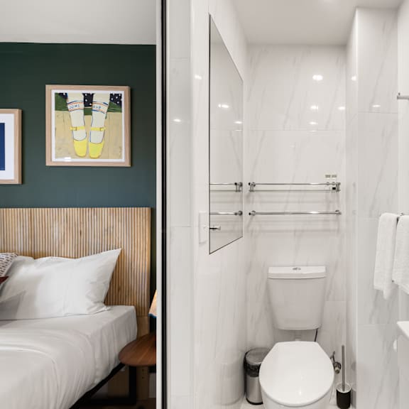 a white toilet sits in a bathroom with a white sink and a white bathtub.