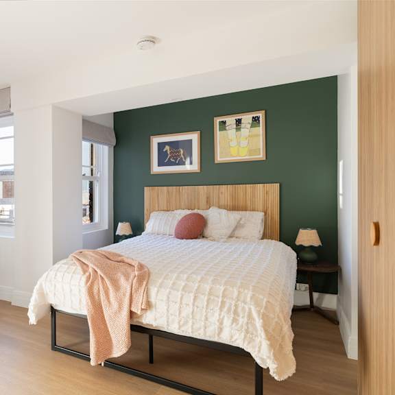 a bedroom with a bed, desk, and chair.